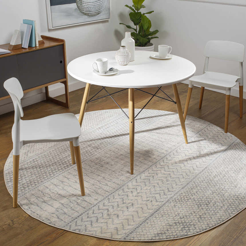 Dining room scene with a round Nunda Gray Rug under a white table and chairs. Roomscene-Round