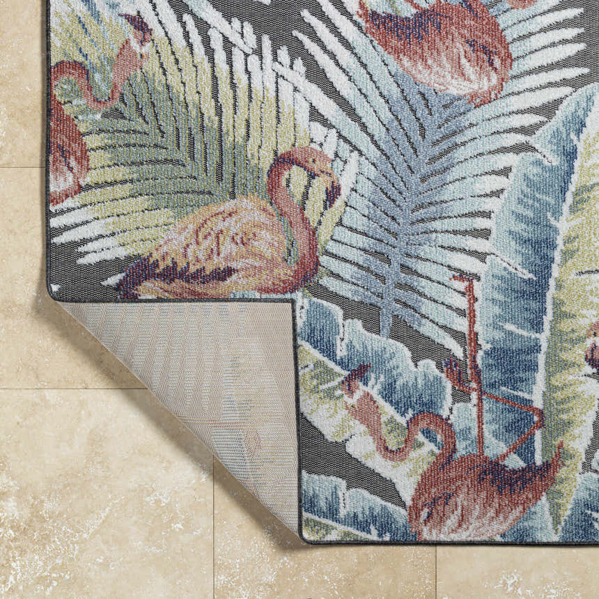 Close up of Nayan Charcoal Area Rug showing flamingo and palm leaf coastal design in blue, cream, olive, and rust colors. Fold