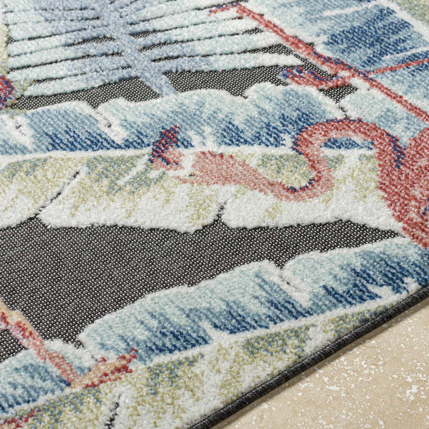 Close-up of Nayan Charcoal Area Rug showing coastal design, blue, cream, and rust colors, and soft polypropylene texture. Texture
