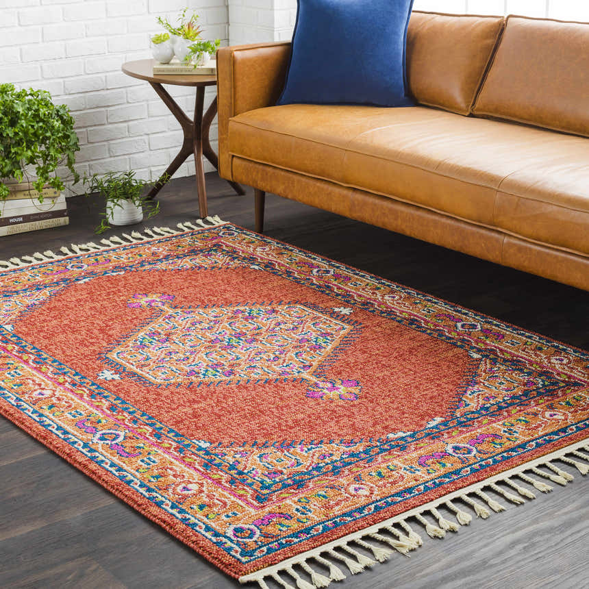 Living room scene with a camel leather sofa and the Oban Traditional Rug in coral and blue. Roomscene-Rectangle