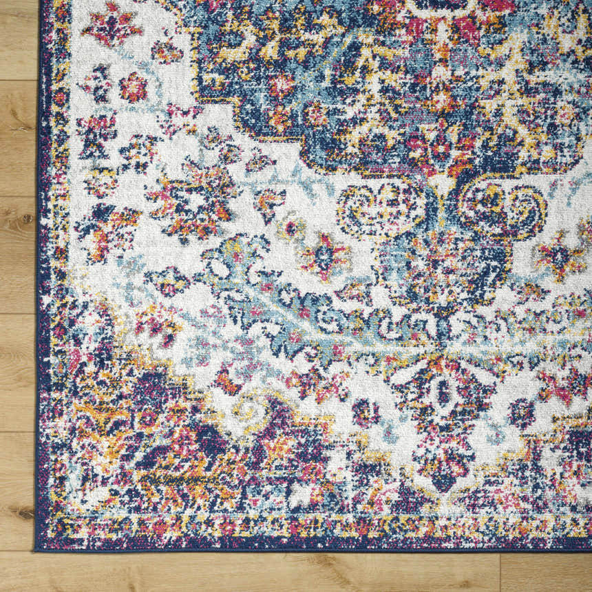 Close-up of the Okarche Area Rug showing its traditional, floral pattern and colors: navy, peach, mustard, and light beige. Swatch