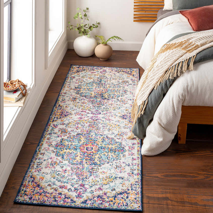 Bedroom scene with Okarche Area Rug. Bohemian style rug in burgundy, orange, teal, and beige colors on dark wood floor. Roomscene-Runner