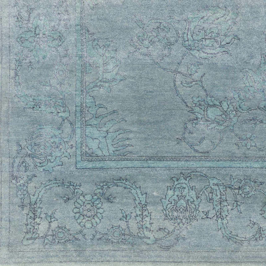 Close-up of the hand-knotted Oxly Area Rug. Farmhouse style rug in blue and sage with a traditional floral pattern. Swatch