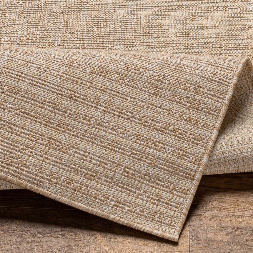 Close-up of the Stephan Dark Beige Outdoor Rug showing its woven texture and neutral color palette. Fold