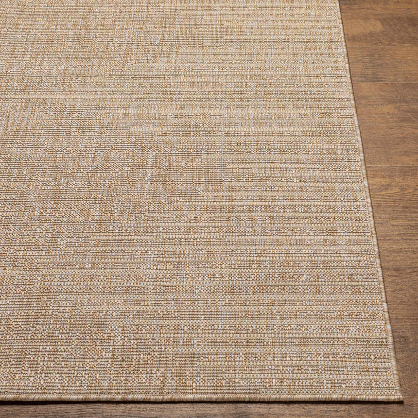 Close-up of the woven texture and neutral colors of the Stephan Dark Beige Outdoor Rug on a wood floor. Front