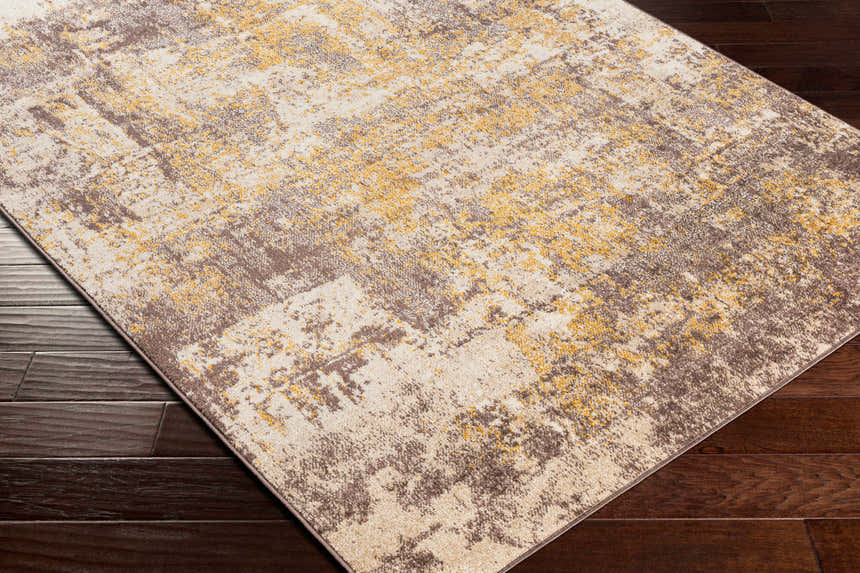 Close up of the Pamantingan Area Rug showing cream, beige, gray, brown and mustard tones on a dark wood floor. Corner