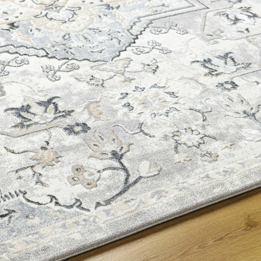 Close-up of Phyre Area Rug. Light gray farmhouse style rug with a traditional floral pattern and soft texture. Texture