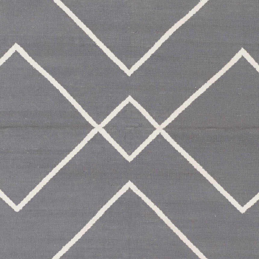 Close-up of the Pinewood Area Rug, a hand woven cotton rug with a gray and off white geometric pattern. Swatch