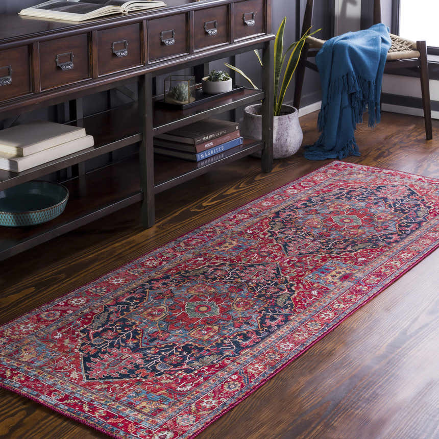 Entryway scene with a Pauline Red Medallion Performance Rug, dark wood console table, books, and blue throw. Roomscene-Runner