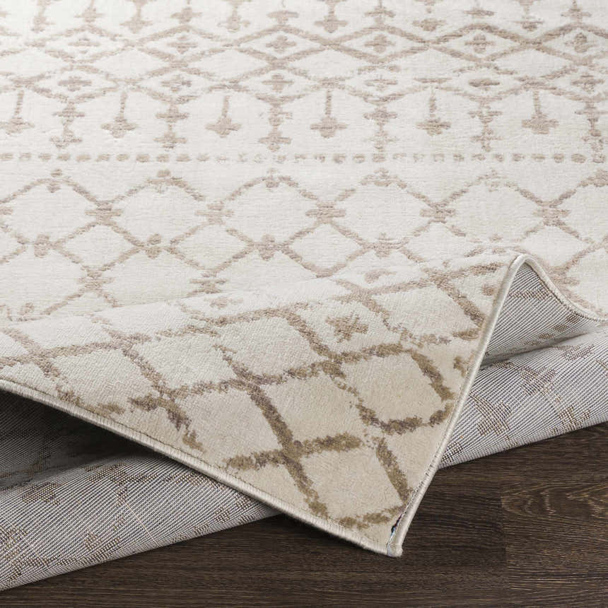 Close-up of the Pineview Area Carpet, showcasing its gray, ivory, and tan Bohemian diamond pattern and machine-woven texture. Fold
