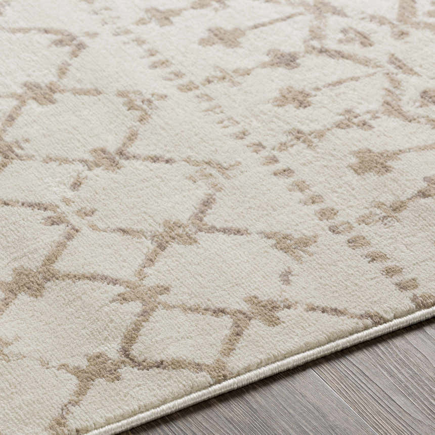 Close-up of the Pineview Area Carpet; a machine-woven rug with a tan geometric pattern on an ivory background. Texture