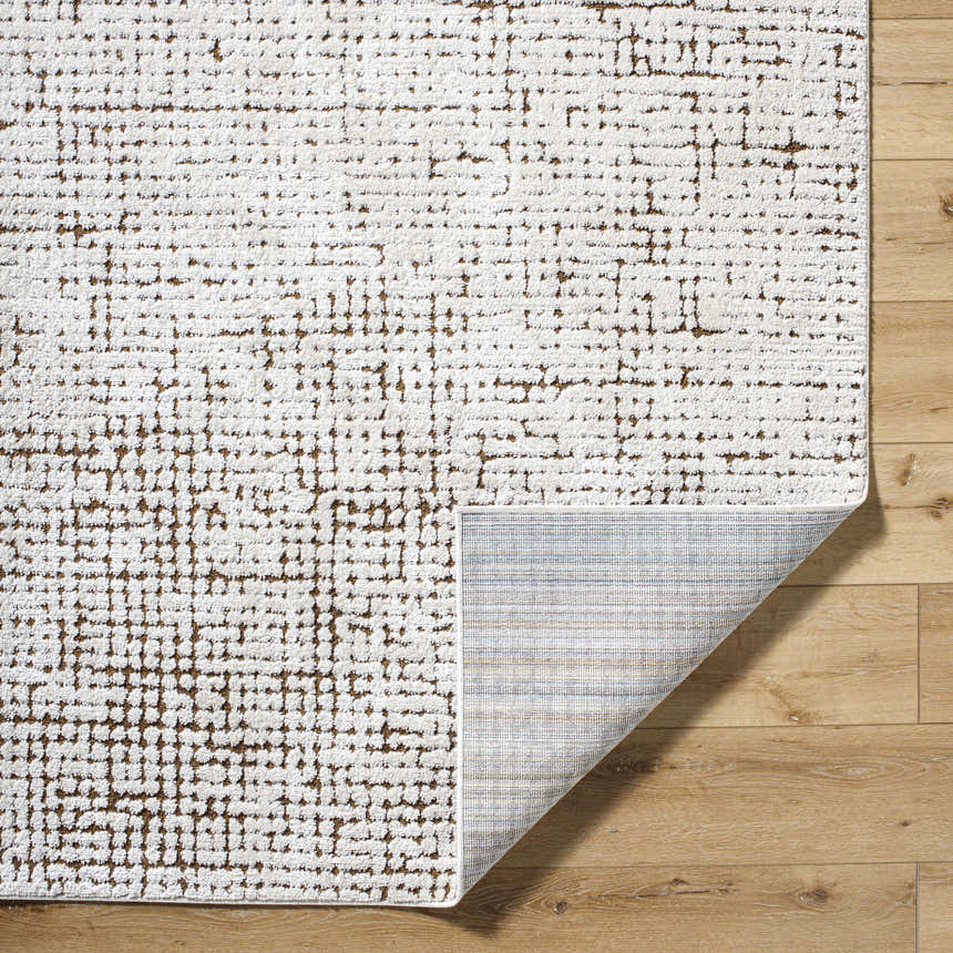 Close-up of Cascade Minimalist Rug: ivory rug with a medium brown geometric pattern on light wood floors. Fold
