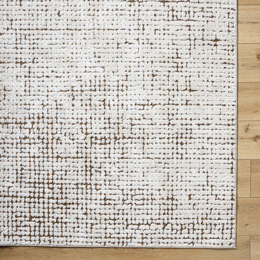 Close-up of Cascade Minimalist Rug by Our PNW Home x Livabliss. Ivory rug with a dark red and medium brown geometric pattern. Corner