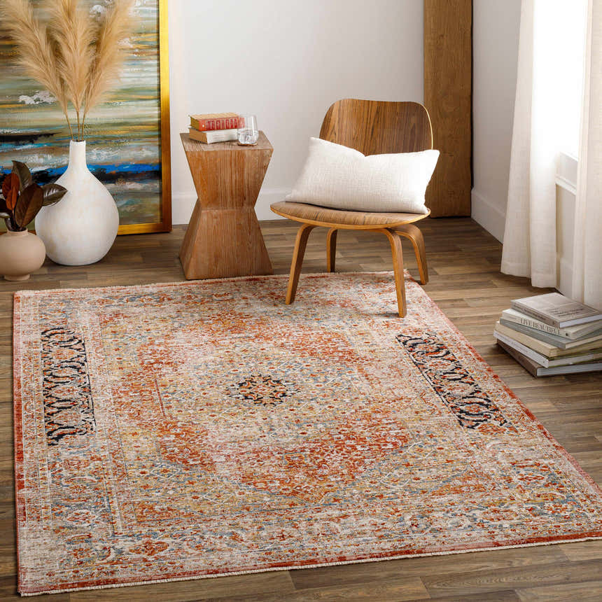 Living room scene with a brick red Polomolok Luxe Performance Rug, wood chair, side table, and neutral decor. Roomscene-Rectangle