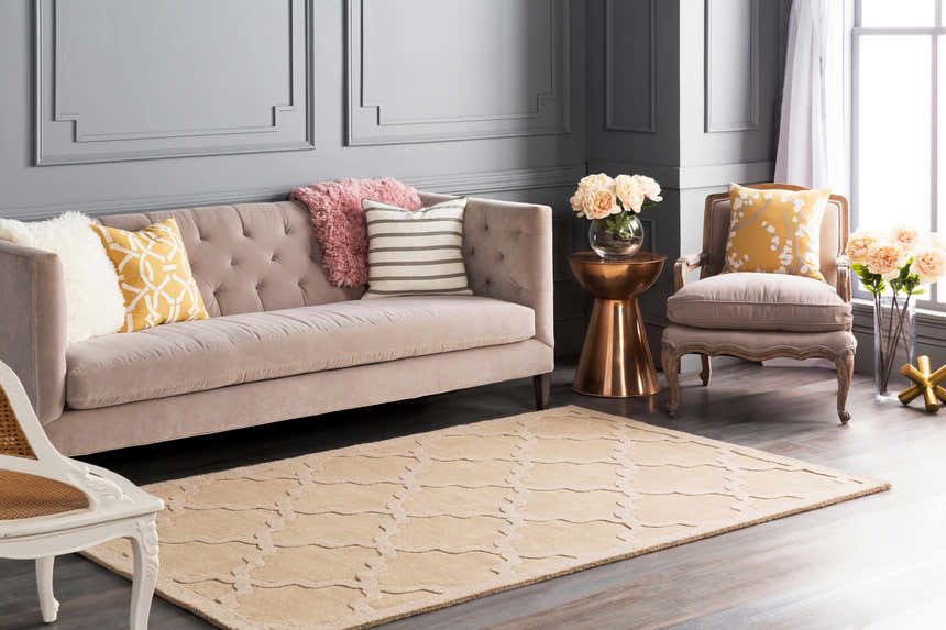 Living room scene with a tan Posen Area Rug, beige sofa, and gray walls creating a contemporary, neutral aesthetic. Roomscene-Rectangle