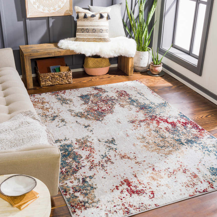 Living room scene with a Prinza Area Carpet in dark gray, red, and blue abstract design. Roomscene-Rectangle