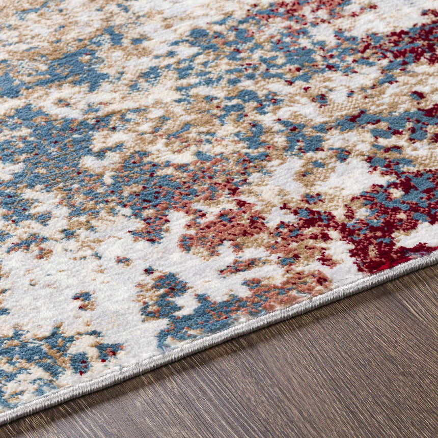 Close-up of the Prinza Area Carpet showcasing its contemporary dark gray, blue, and nutmeg abstract pattern. Texture