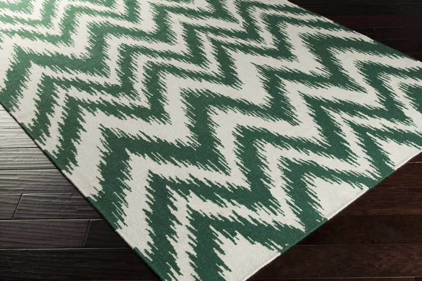 Parsonsfield Area Rug, cream and green wool rug with a bohemian zigzag pattern on dark wood floors. Corner