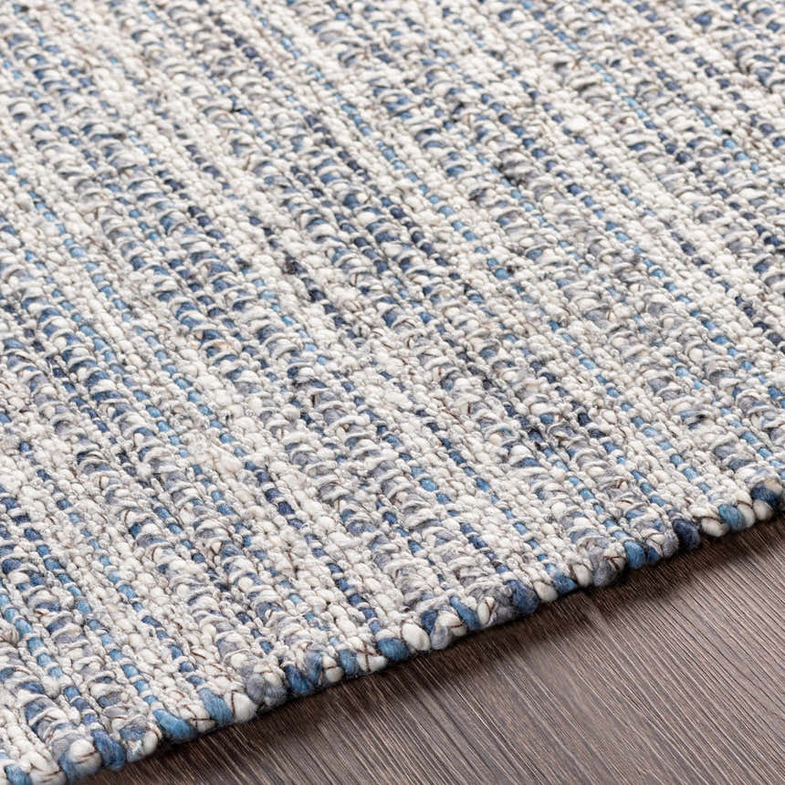 Close-up of the hand-loomed Potterspury Area Rug. Blue, cream, and gray wool and polyester fibers create a textured, contemporary design. Texture