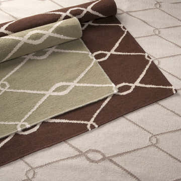 Close-up of Pudsey Area Rug showing light beige, olive, and brown color variations with a geometric trellis pattern. Styleshot