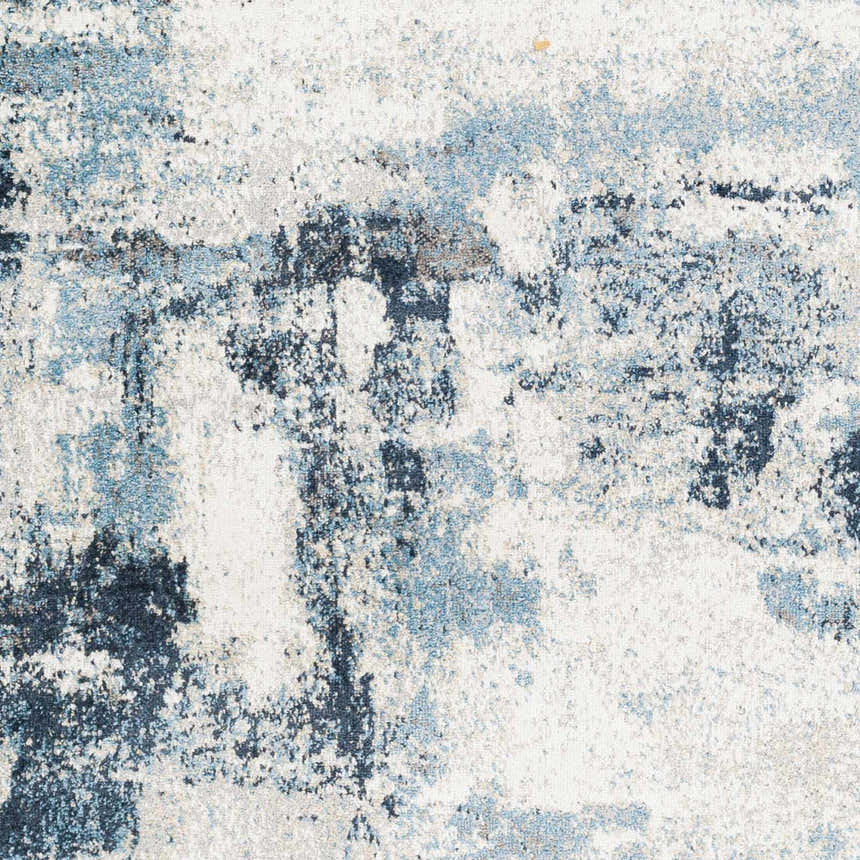 Close-up of the Pugo Washable Area Rug, showcasing its abstract pattern in blue, cream, and light gray tones. Swatch