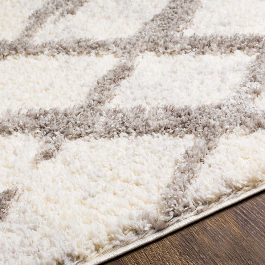 Close up of the plush Putat Area Rug. Gray geometric pattern on a white rug. Texture
