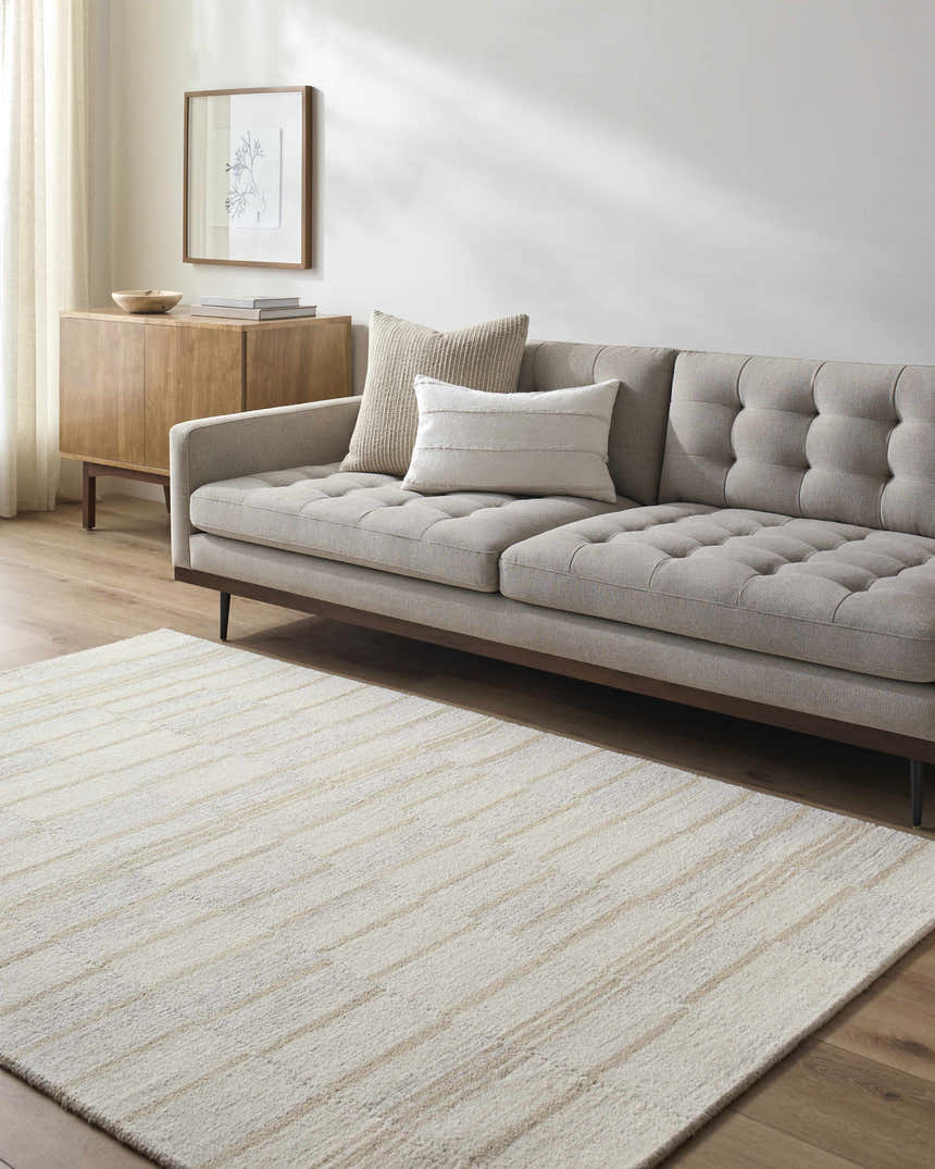 Living room with a taupe sofa and the cream and tan striped Paiva Modern Wool Rug. Roomscene-Rectangle