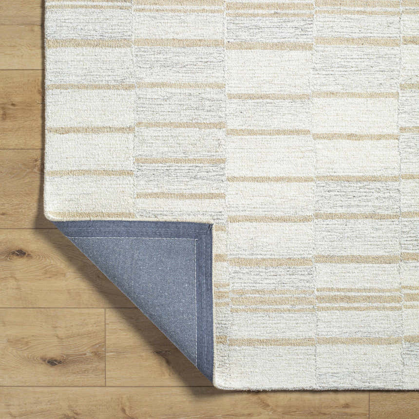 Close-up of the hand-tufted Paiva Modern Wool Rug. Cream, tan, and taupe stripes create a farmhouse, transitional design. Fold