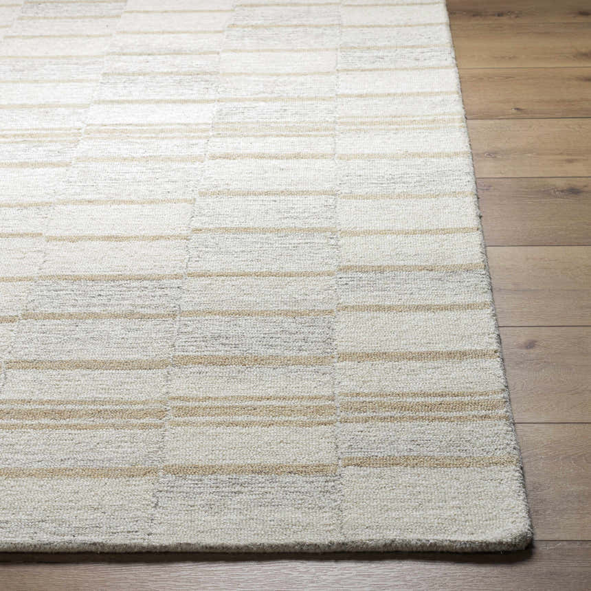Close-up of the hand-tufted Paiva Modern Wool Rug. Cream, tan, and taupe stripes create a subtle geometric pattern. Front