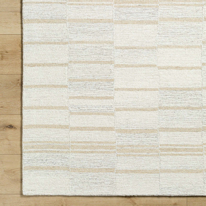 Close-up of the hand-tufted Paiva Modern Wool Rug. Cream, tan, and taupe stripes on a textured wool surface. Corner