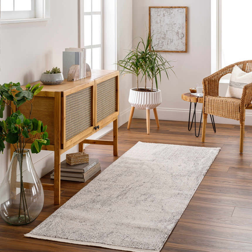 Hallway scene with a Rahm Ivory Marble Area Rug, wood console table, and woven chair. Roomscene-Runner