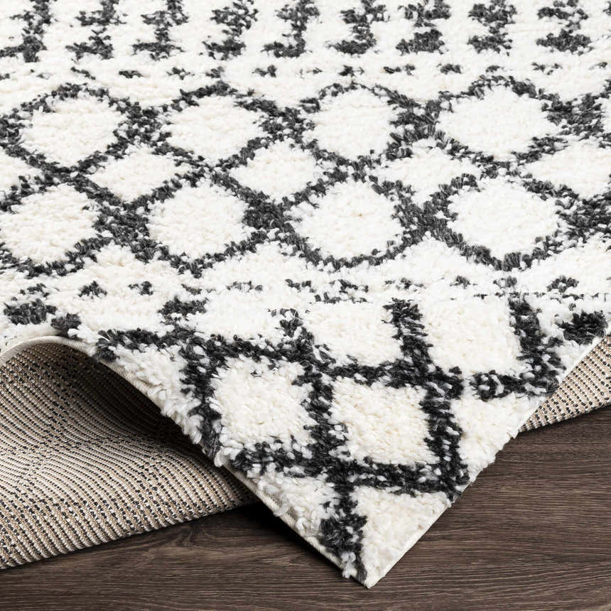 Close up of the plush Walkern White/Black rug showing its geometric pattern and soft texture. Fold