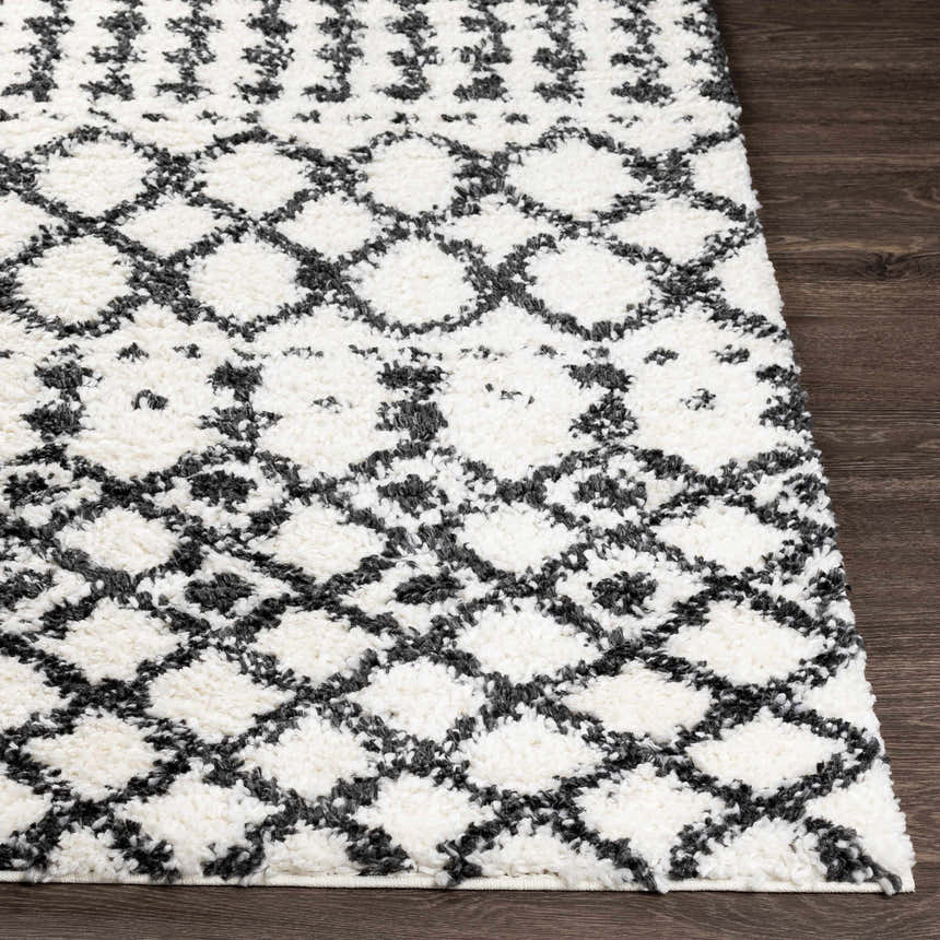 Close-up of the plush Walkern White/Black rug. Features a geometric diamond pattern in black on a cream shag pile. Front