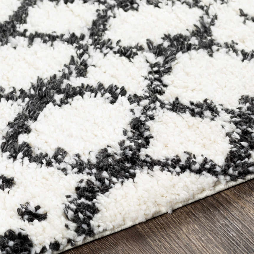 Close-up of Walkern White/Black plush rug showing its shag texture and geometric black and cream pattern. Texture