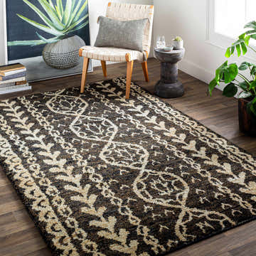 Entryway with Redondo Premium Hand Knotted Jute Carpet. Beige and brown rug with bohemian pattern, chair, and plant. Roomscene-Rectangle