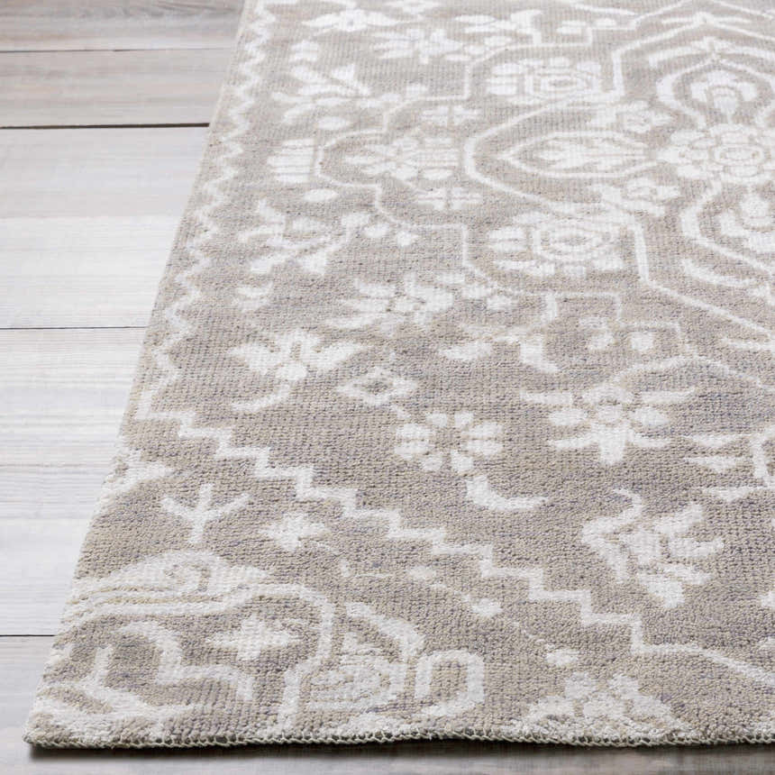 Close-up of the Roxobel Clearance Rug. Light gray wool rug with traditional, floral pattern in medium gray. Hand-knotted texture. Front