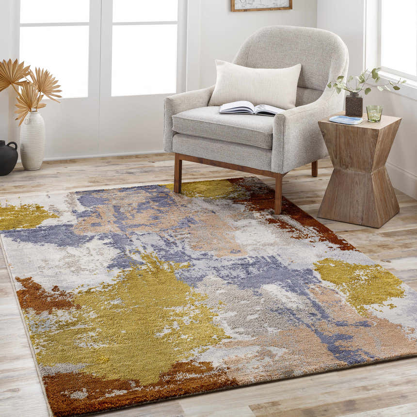 Living room scene with a Rivers Area Rug in brick red, blue, gold, and gray under a chair and side table. Roomscene-Rectangle