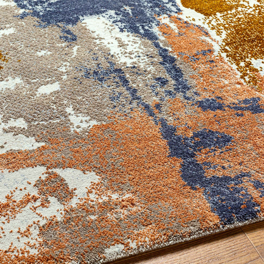 Close up of the Rivers Area Rug showcasing brick red, dark blue, and mustard colors. Abstract pattern. Texture