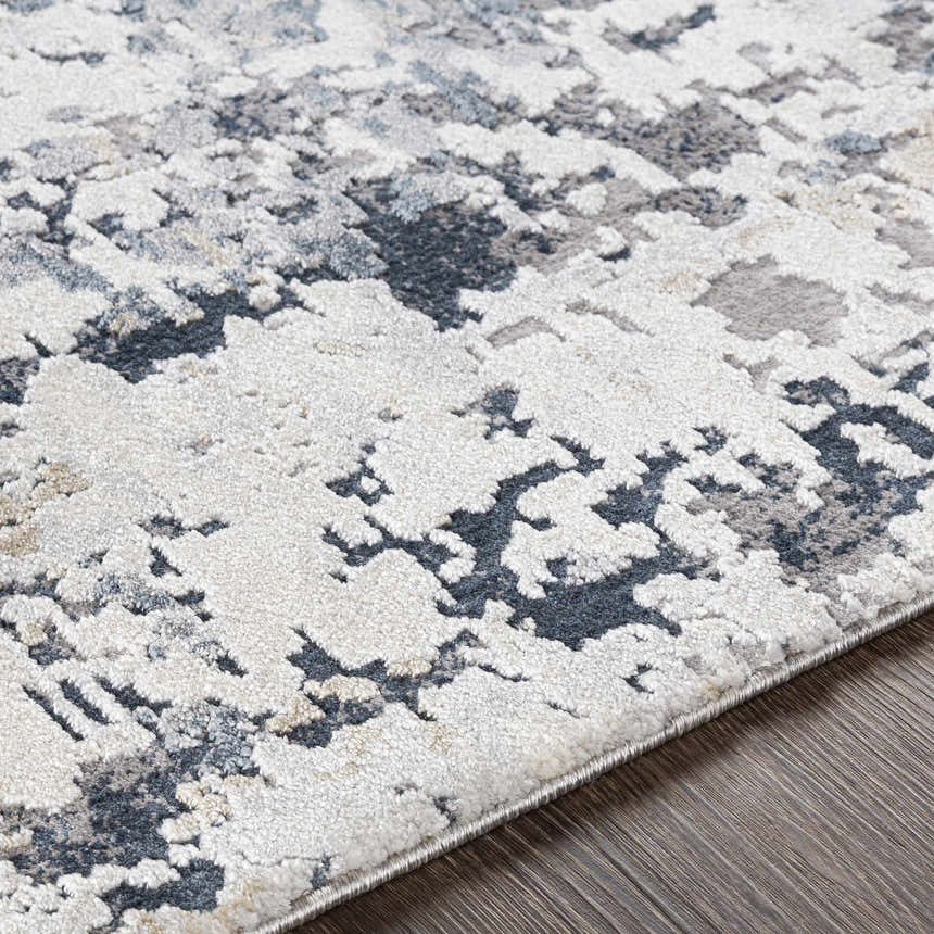 Close-up of the Ryhill Textured Luxe Area Rug; contemporary style with charcoal, blue, beige, and gray abstract pattern. Texture