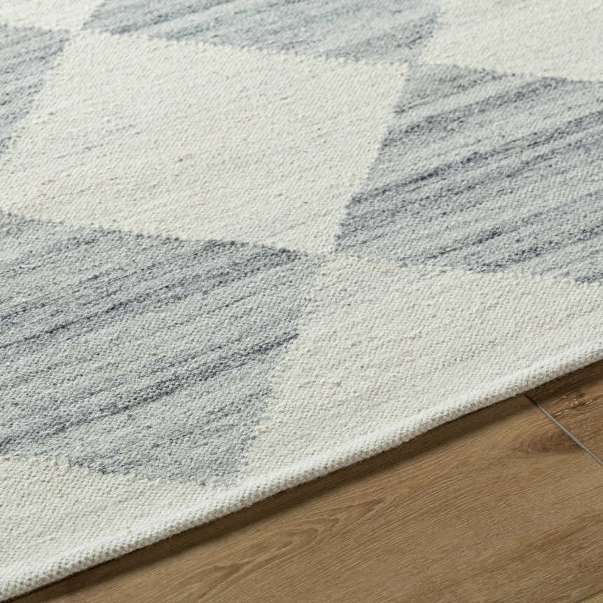 Close-up of the hand woven Rakin Pearl Area Rug. Ivory and silver gray diamond pattern on a farmhouse style cotton and wool rug. Texture