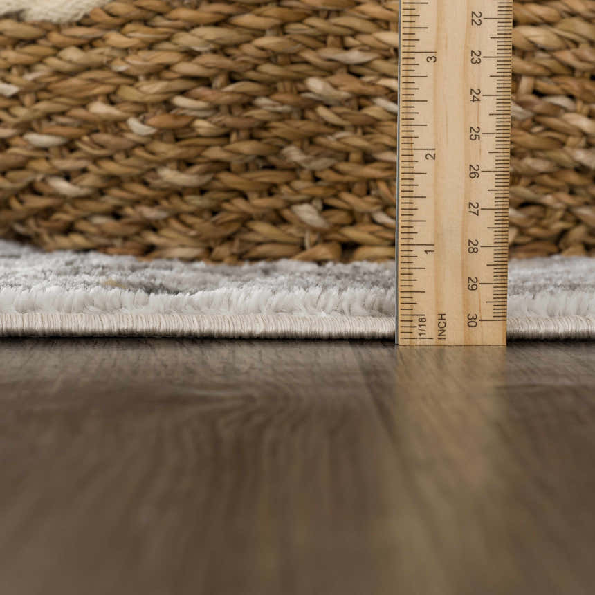 Close-up of the Liverpool Light Gray Area Rug showing the rug's pile height and texture with a ruler for scale. Pile
