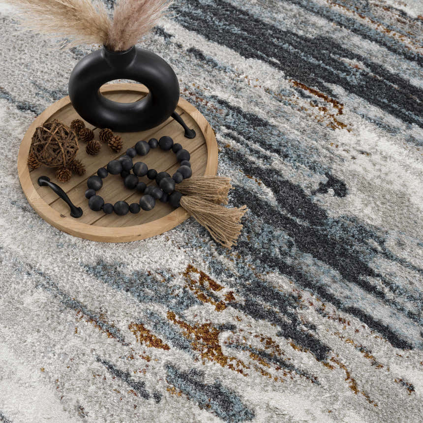 Close-up of the Colorful Liverpool Area Rug. Contemporary design with gray, blue, and brown tones. Styleshot