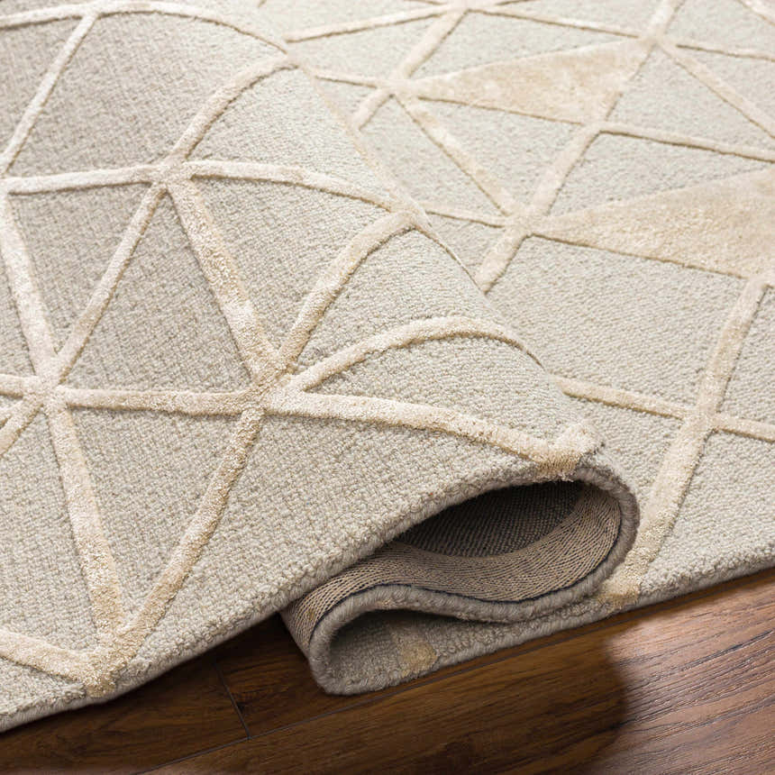 Close-up of the Botiu Blue Geometric rug showing the wool texture and light gray and pearl geometric design. Fold