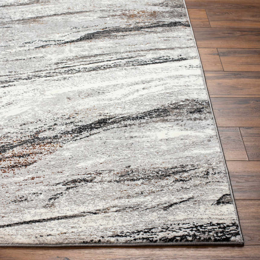 Close-up of Glain Gray & Brown Marble Area Rug showing the abstract pattern, colors, and soft texture next to hardwood flooring. Front