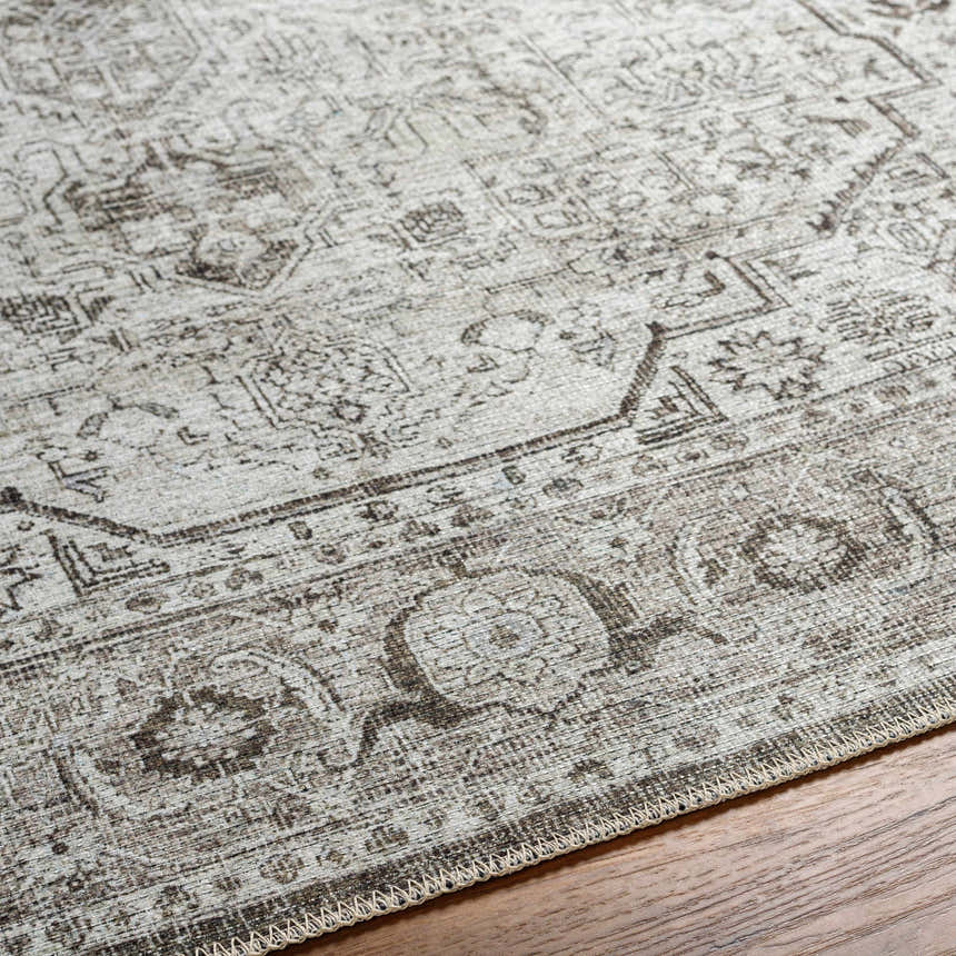 Close up of the Anzu Washable Rug showing its traditional charcoal and light gray pattern and textured polyester weave. Texture
