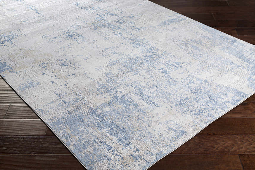 Close-up of the Sapcote Textured Luxe Area Rug, showcasing its light blue, beige, and gray contemporary design. Corner