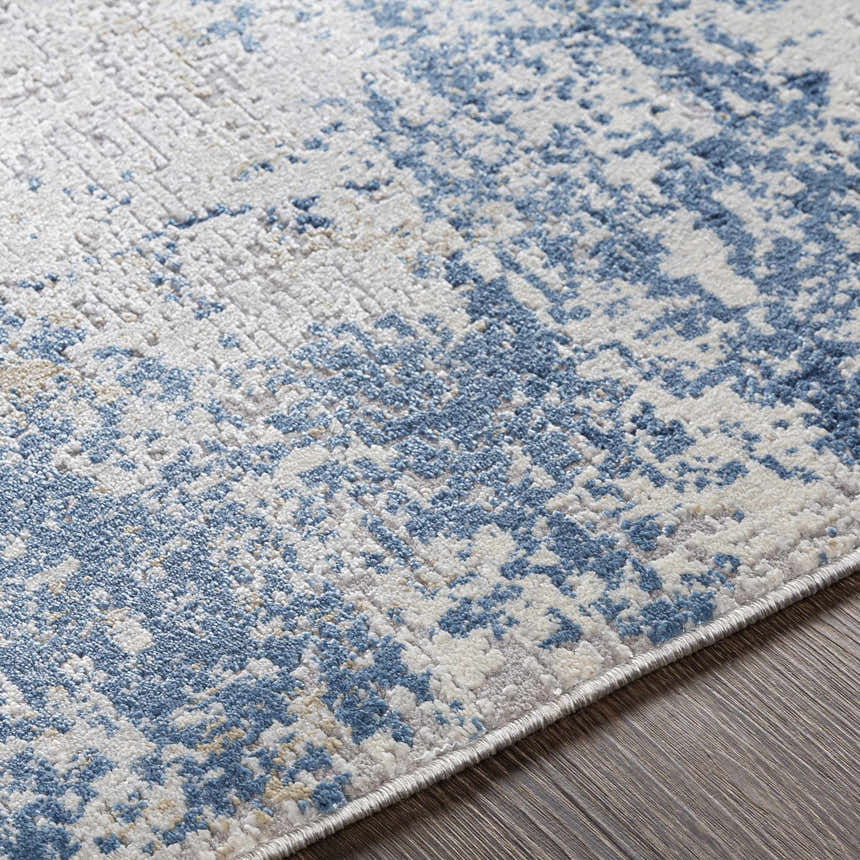 Close-up of the Sapcote Textured Luxe Area Rug, featuring an abstract pattern in light blue, beige, and white. Texture
