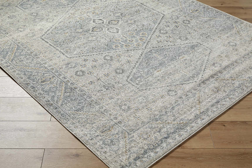 Close-up of the Nydia Blue Medallion Area Rug showing its traditional pattern, blue, gray, cream, and mustard colors. Corner