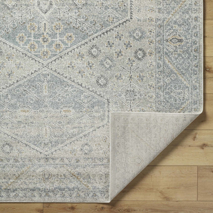 Close up of the Nydia Blue Medallion Area Rug showing the traditional pattern, colors, and texture. Fold