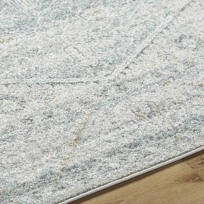 Close-up of the Nydia Blue Medallion Area Rug showing its blue, charcoal, and cream farmhouse design and soft texture. Texture